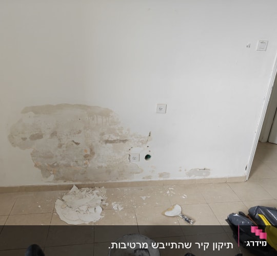 קיר עם תיקוני טיח וכלים על הרצפה